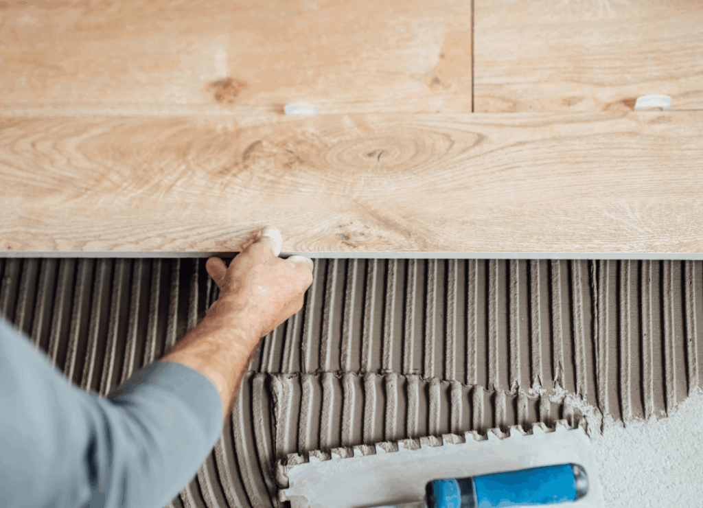 Hombre instalando piso de porcelanato con herramientas de colocación, ilustrando errores comunes durante la instalación