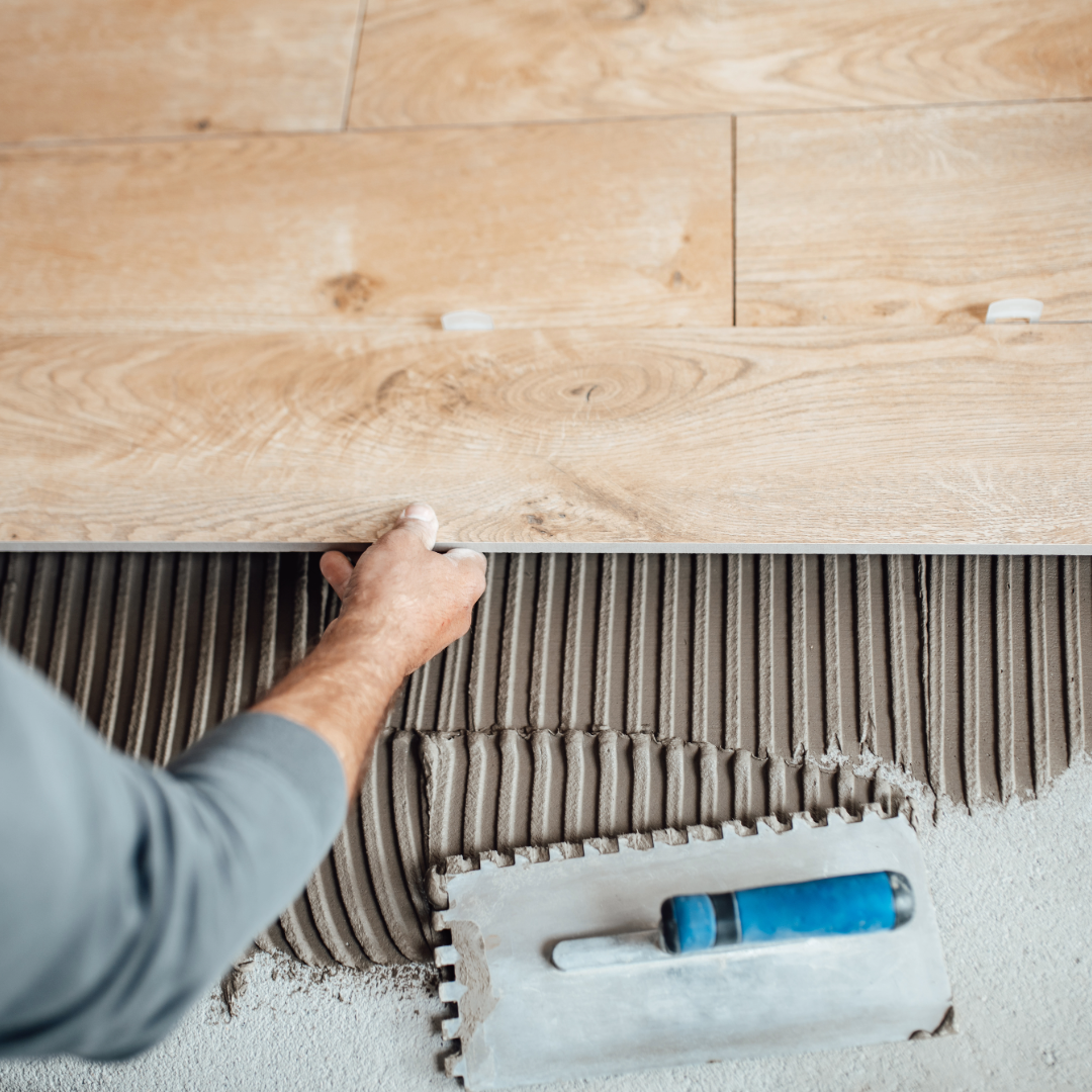 Hombre instalando piso de porcelanato con herramientas de colocación, ilustrando errores comunes durante la instalación