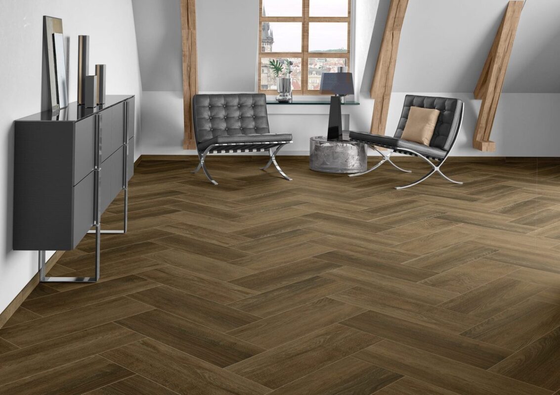 Piso tipo madera Decker de Cesantoni instalado en patrón herringbone (espiga) en sala moderna con sillones Barcelona disponible en Grupo Dalvi Puebla